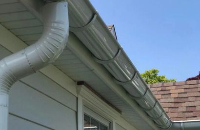 A white gutter is on the side of a house.