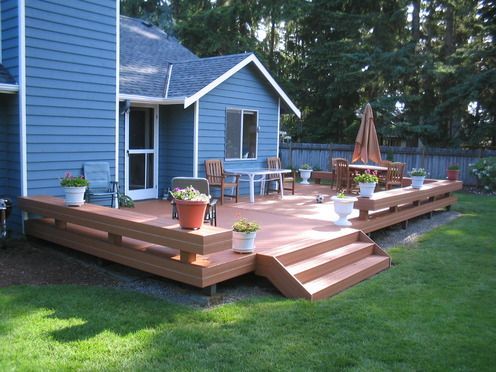 A blue house with a large deck in front of it