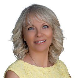 Man smiling, wearing a blue and white checkered shirt.