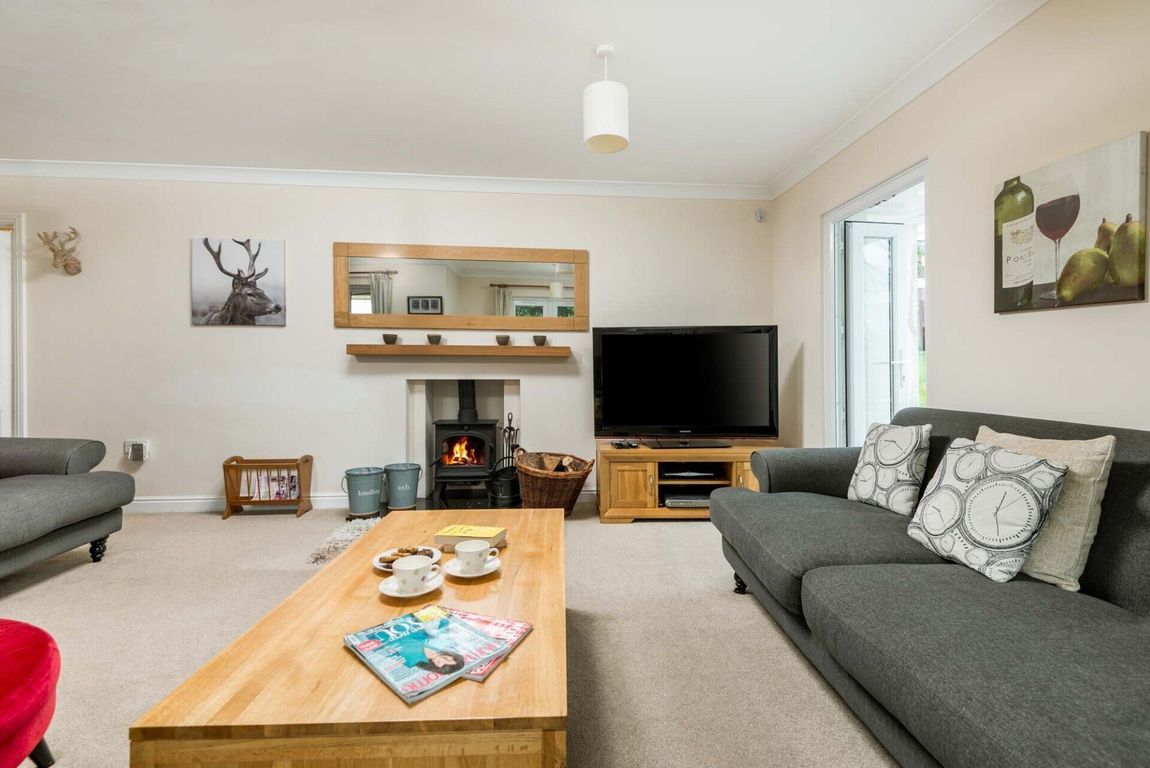 A fire is in the wood stove in the spacious lounge of this New Forest Holiday let