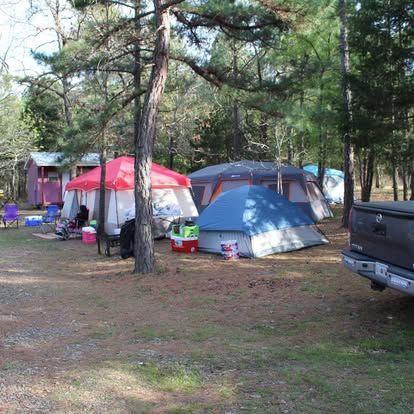 A truck is parked in front of a campground with tents