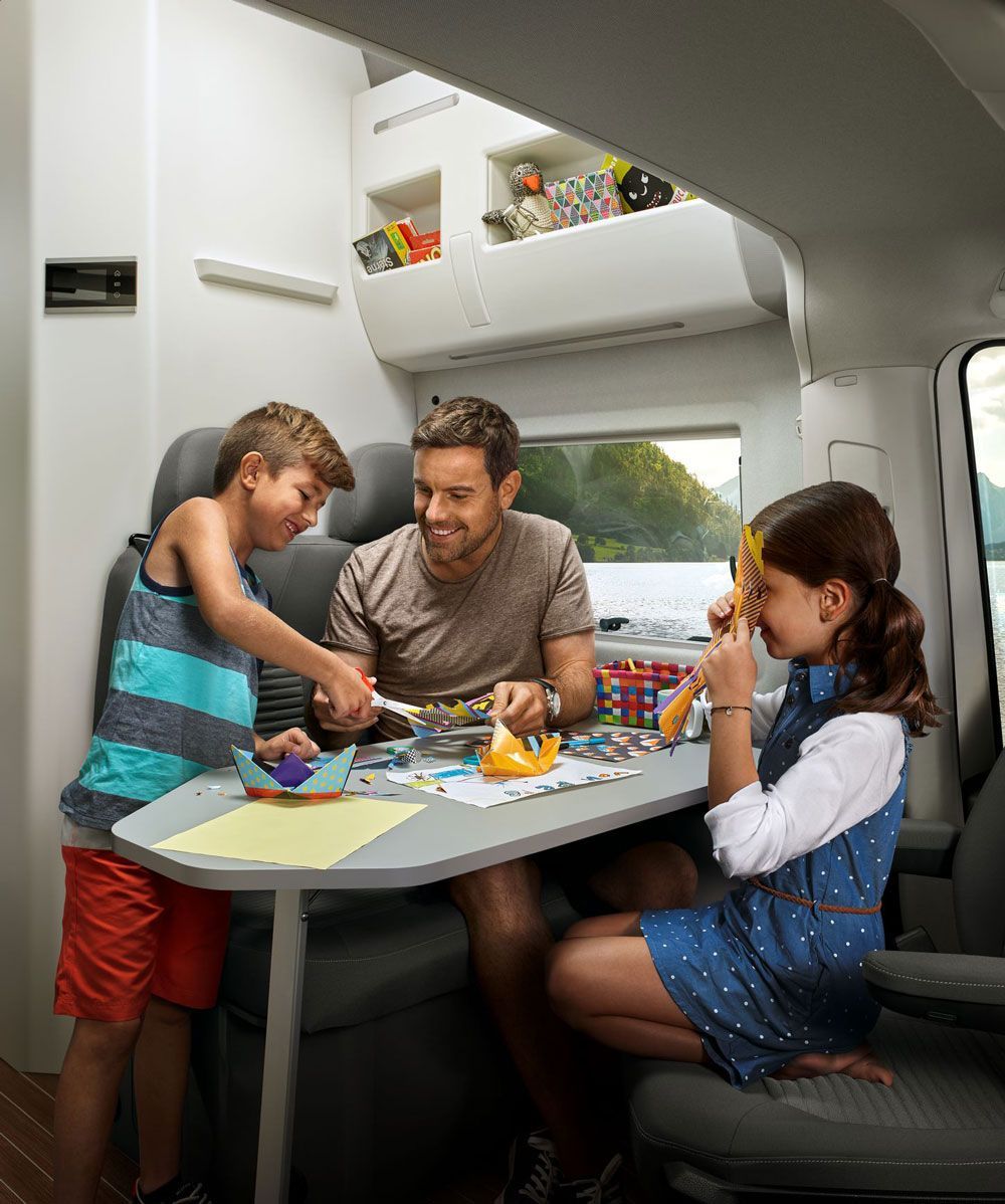 family in dining area of vw grand california hire vehicle