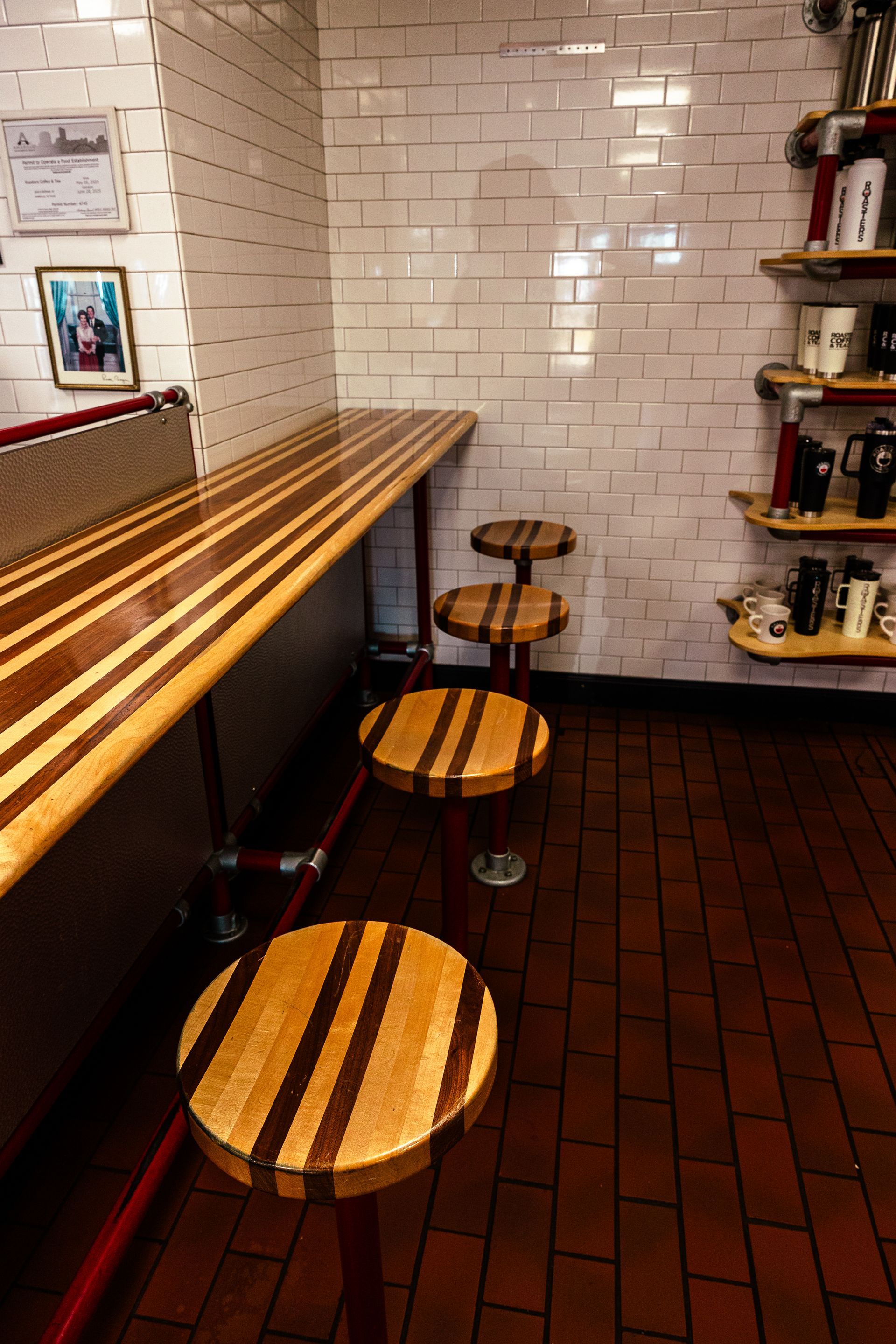 A restaurant with a long wooden table and stools