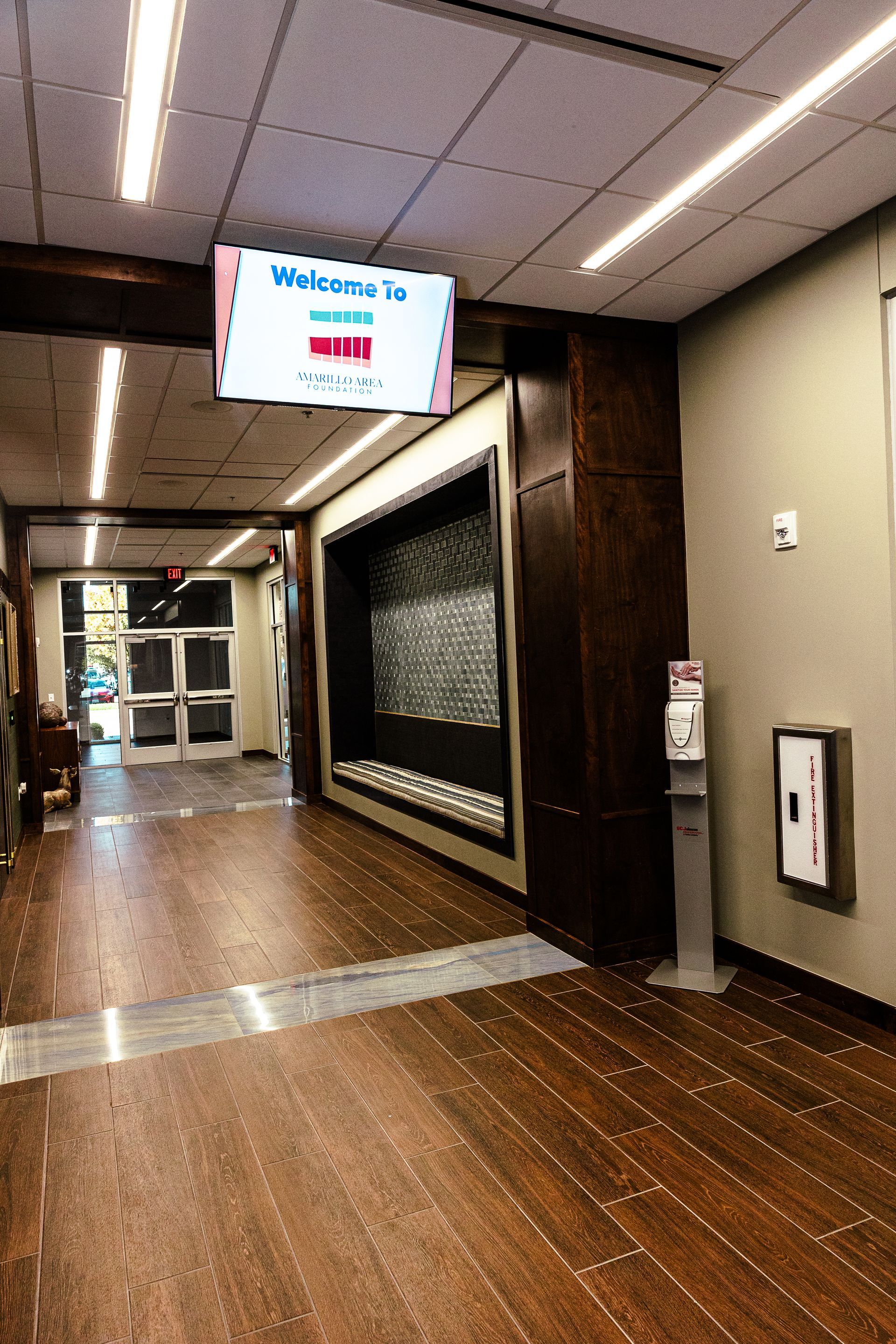 A hallway with a tv on the ceiling that says welcome