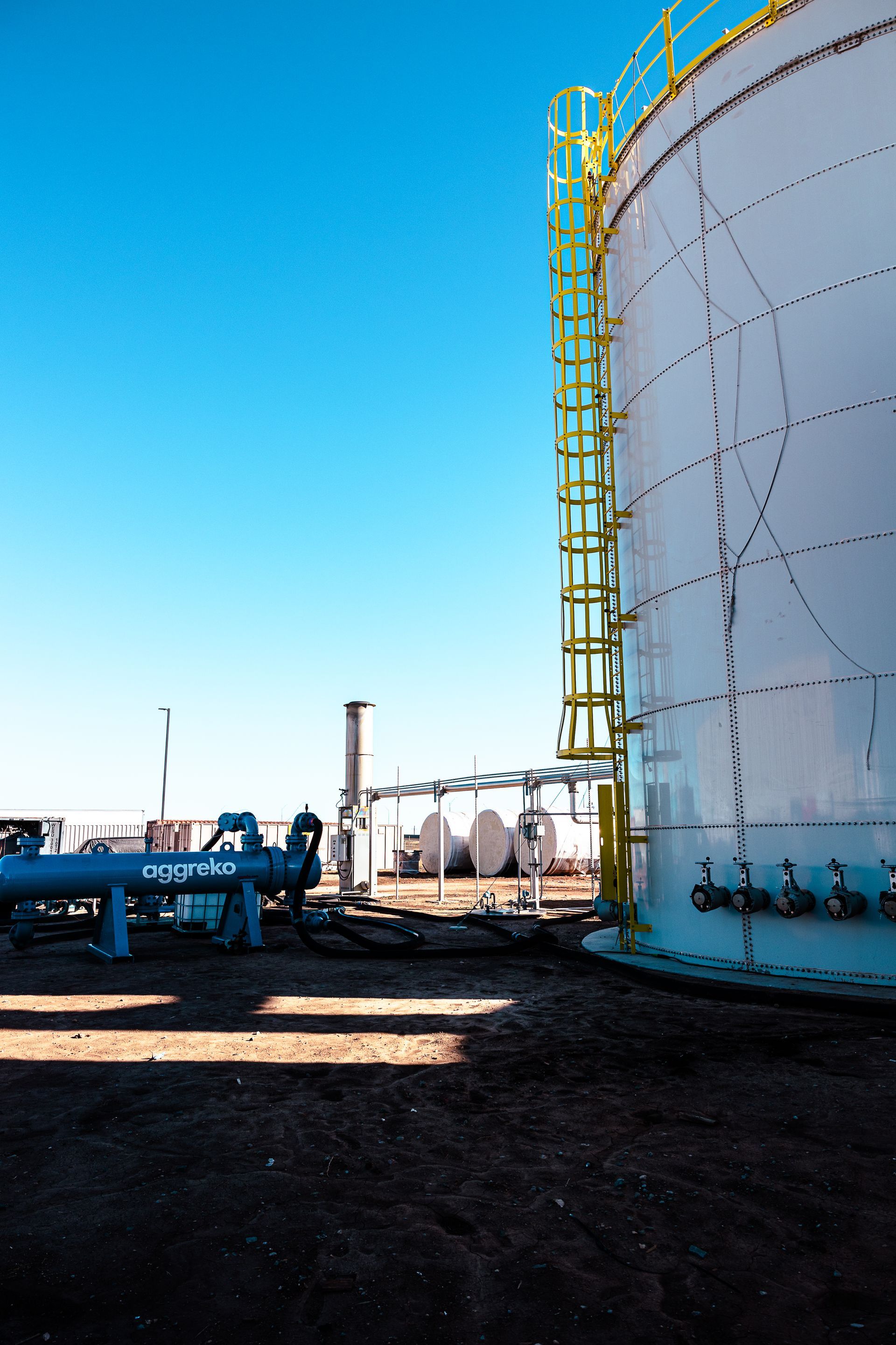 A large white tank with a yellow ladder attached to it