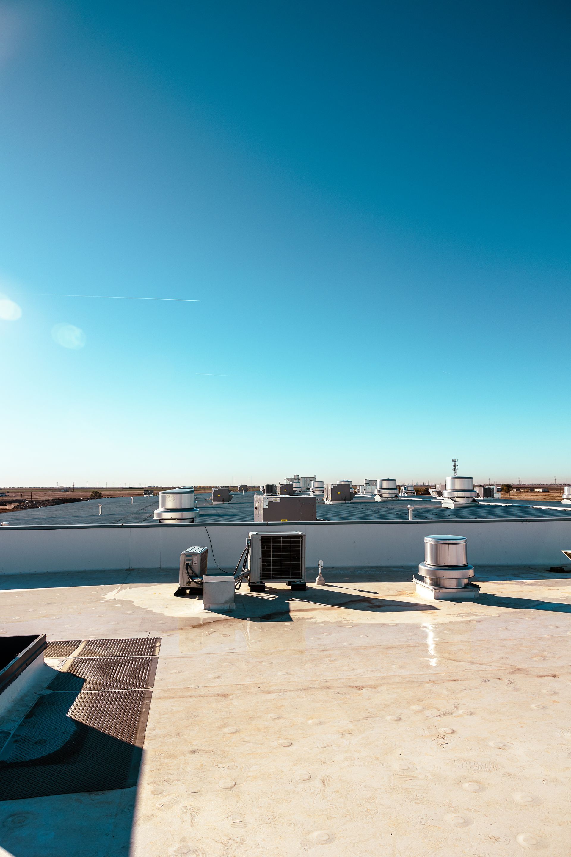 A rooftop view of a building with a blue sky in the background.