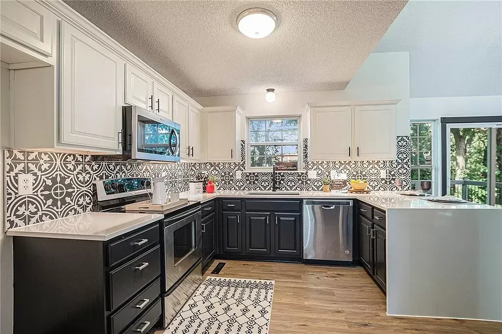 a kitchen with black cabinets and stainless steel appliances .