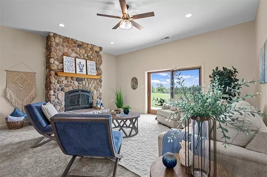 a living room with a fireplace and a ceiling fan .