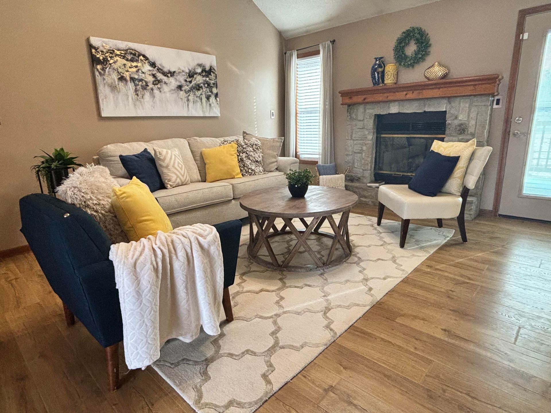 a living room with a couch , chair , coffee table and fireplace .