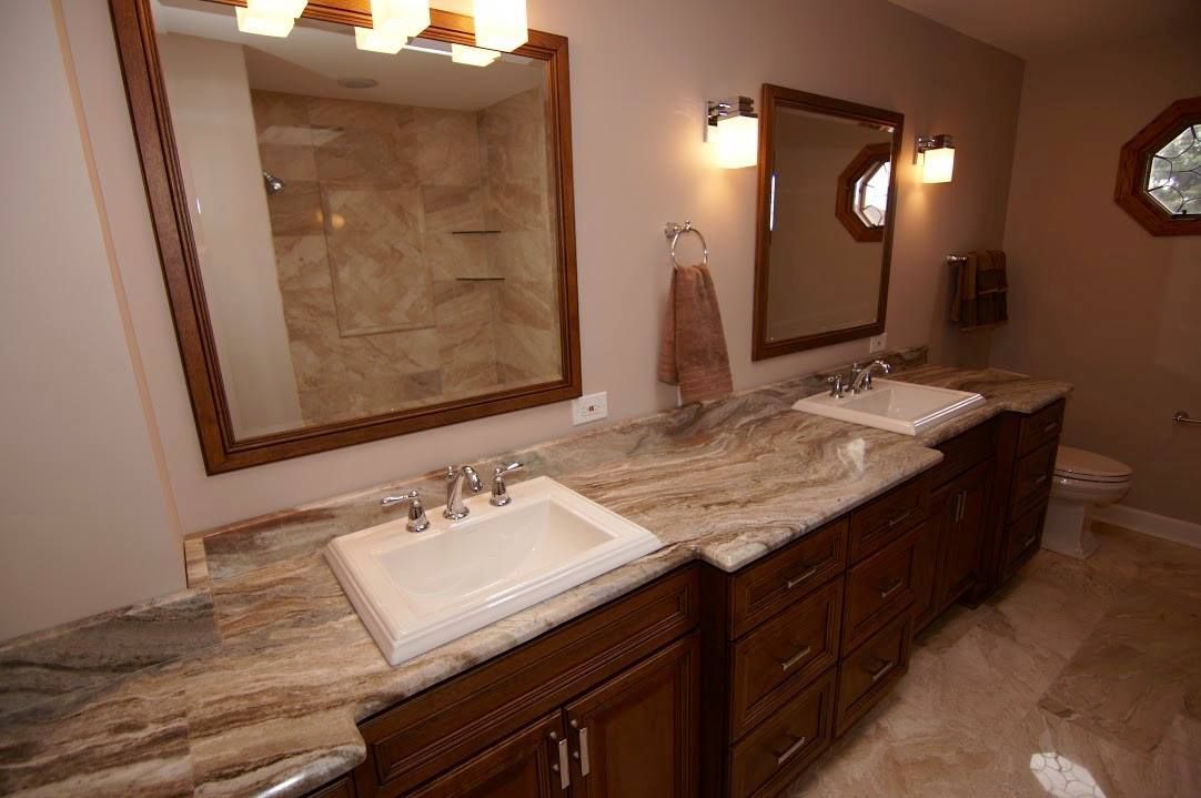 A person with a yellow hard hat drills into a kitchen cabinet. A person with a yellow hard hat drills into a kitchen cabinet.