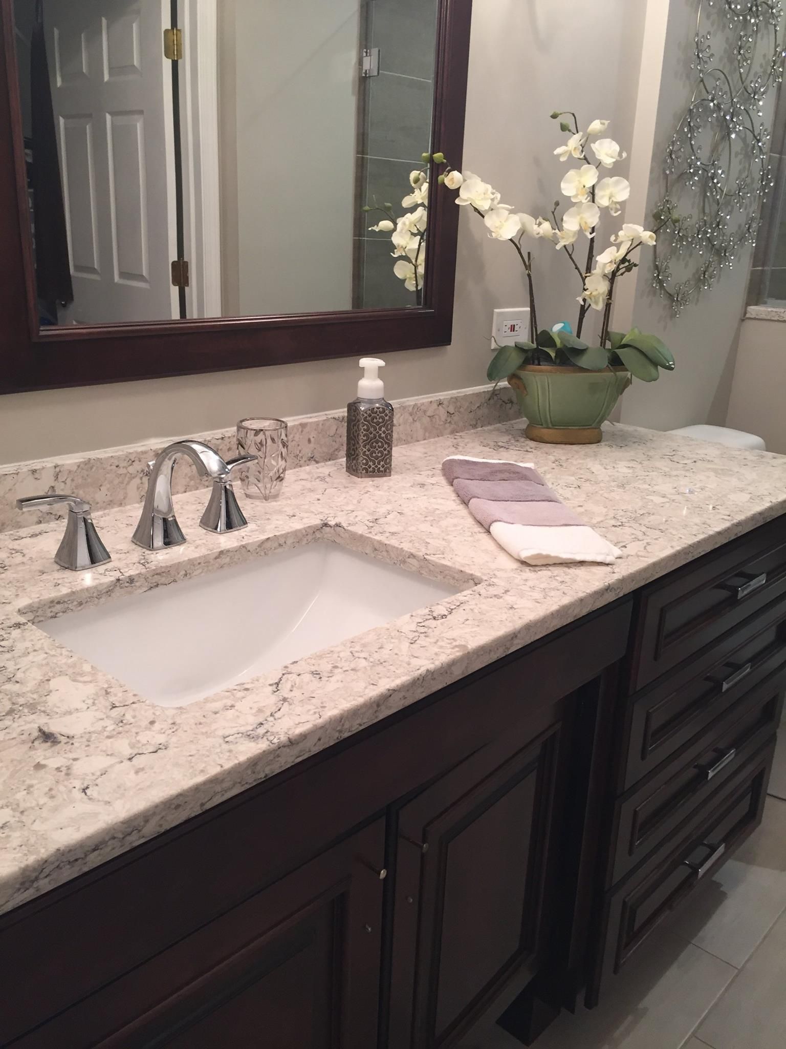 A person with a yellow hard hat drills into a kitchen cabinet. A person with a yellow hard hat drills into a kitchen cabinet.