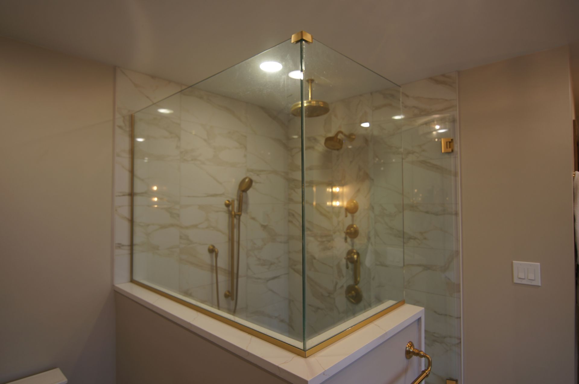 A woman and a man looking at blueprints in a remodeled bathroom. The man points to the plans.