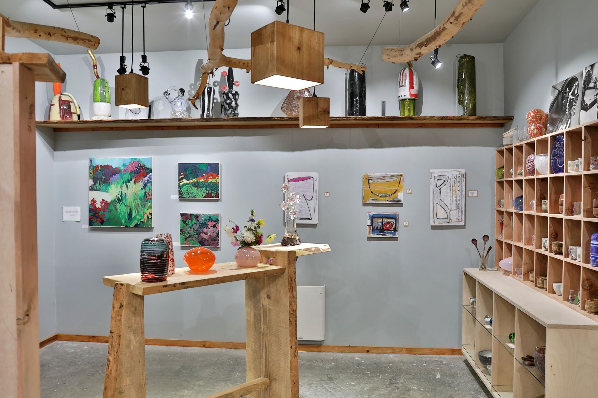 Art gallery interior with paintings, sculptures, and various art objects displayed.