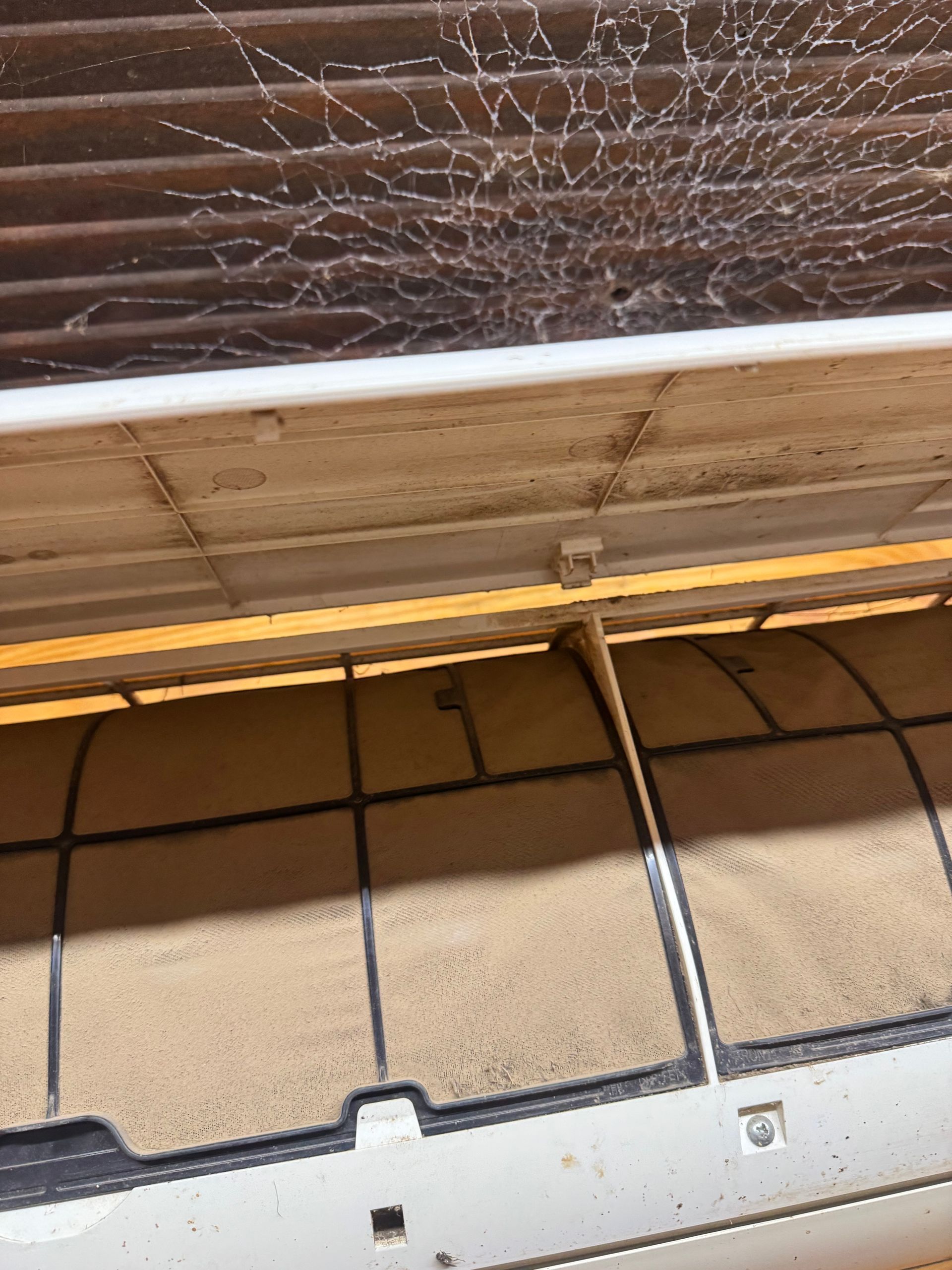 A close up of an air conditioner with a broken filter
