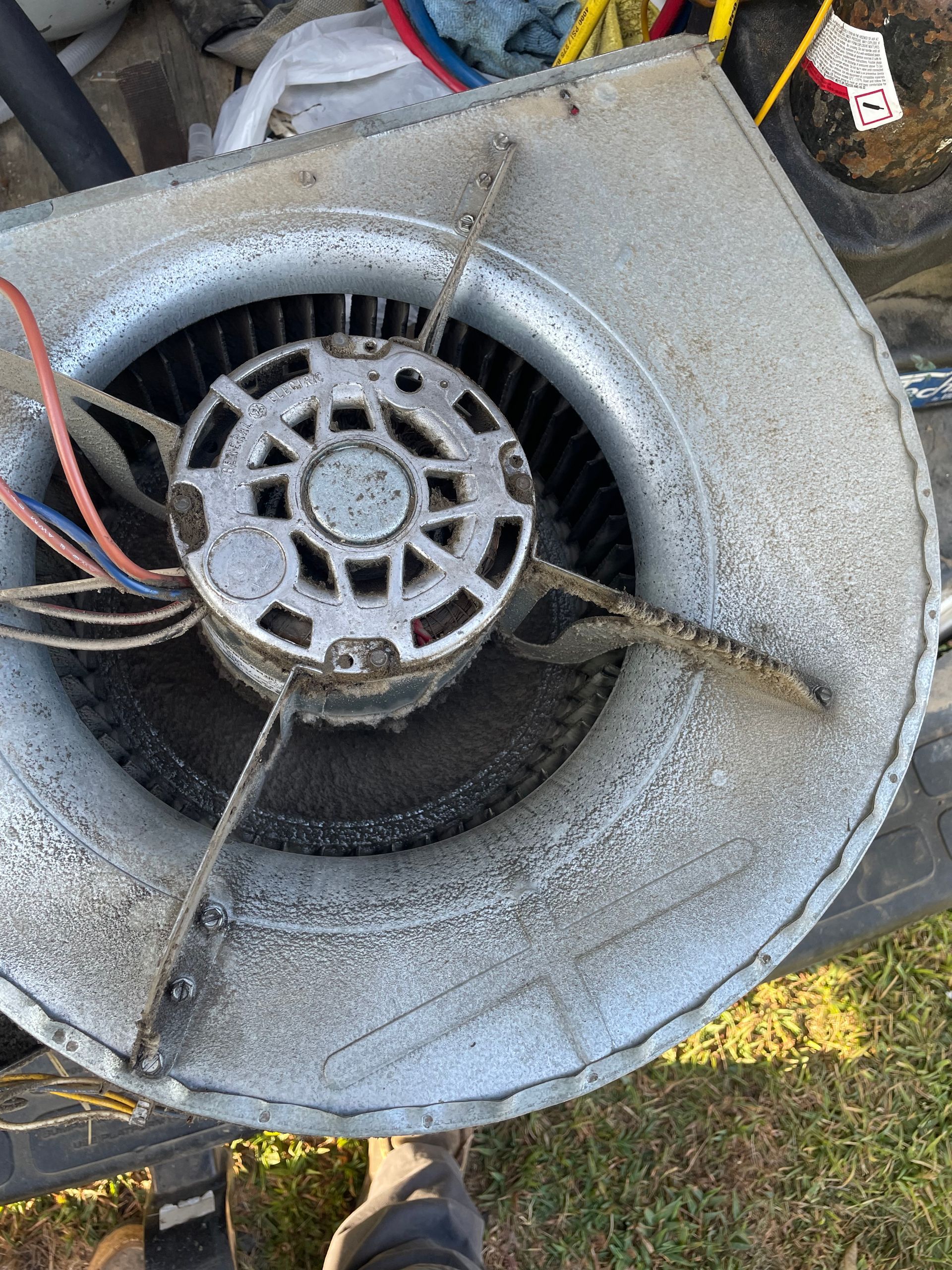 A close up of a dirty fan with a motor inside of it.