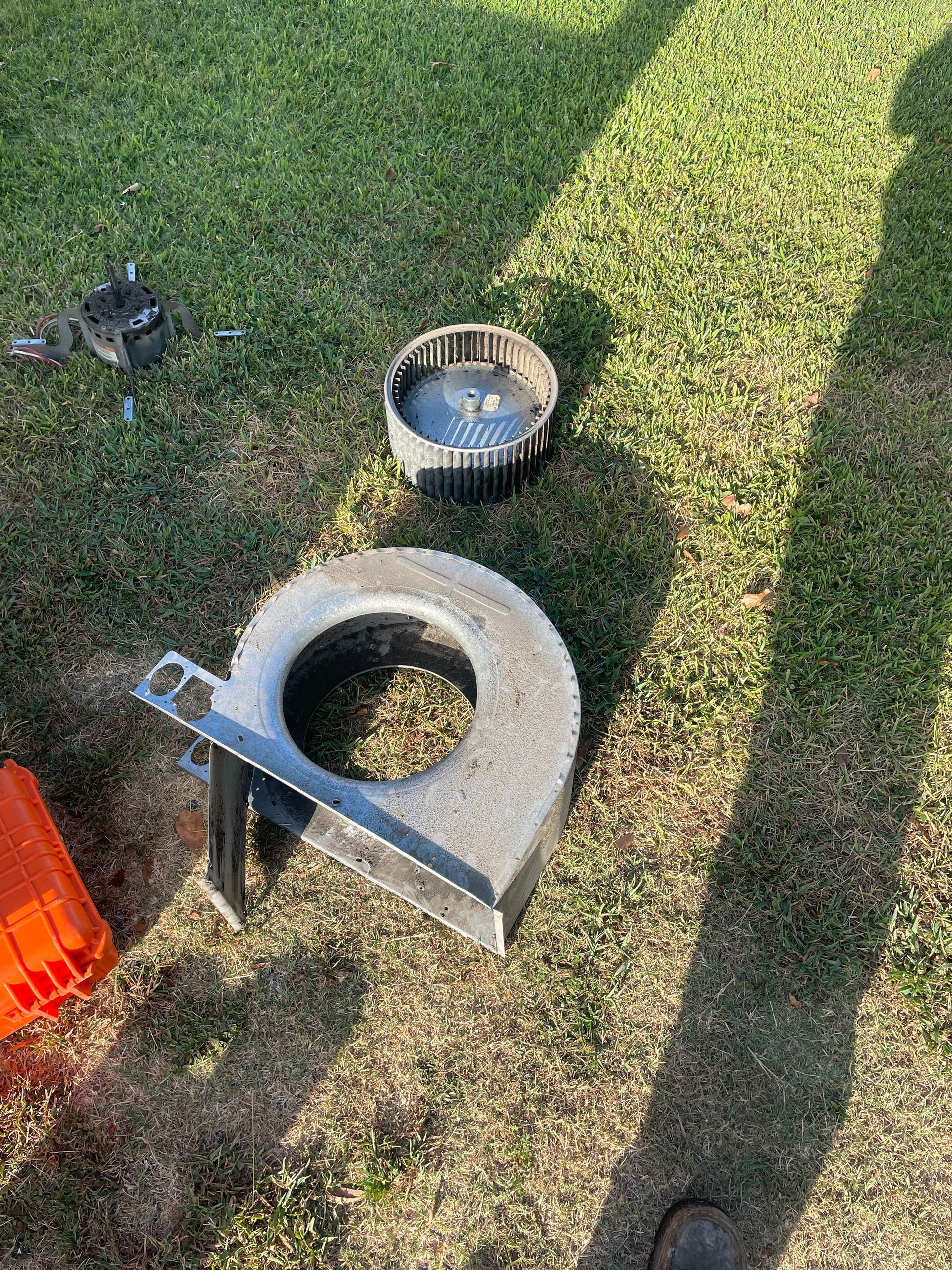 A piece of metal is sitting on top of a lush green field.