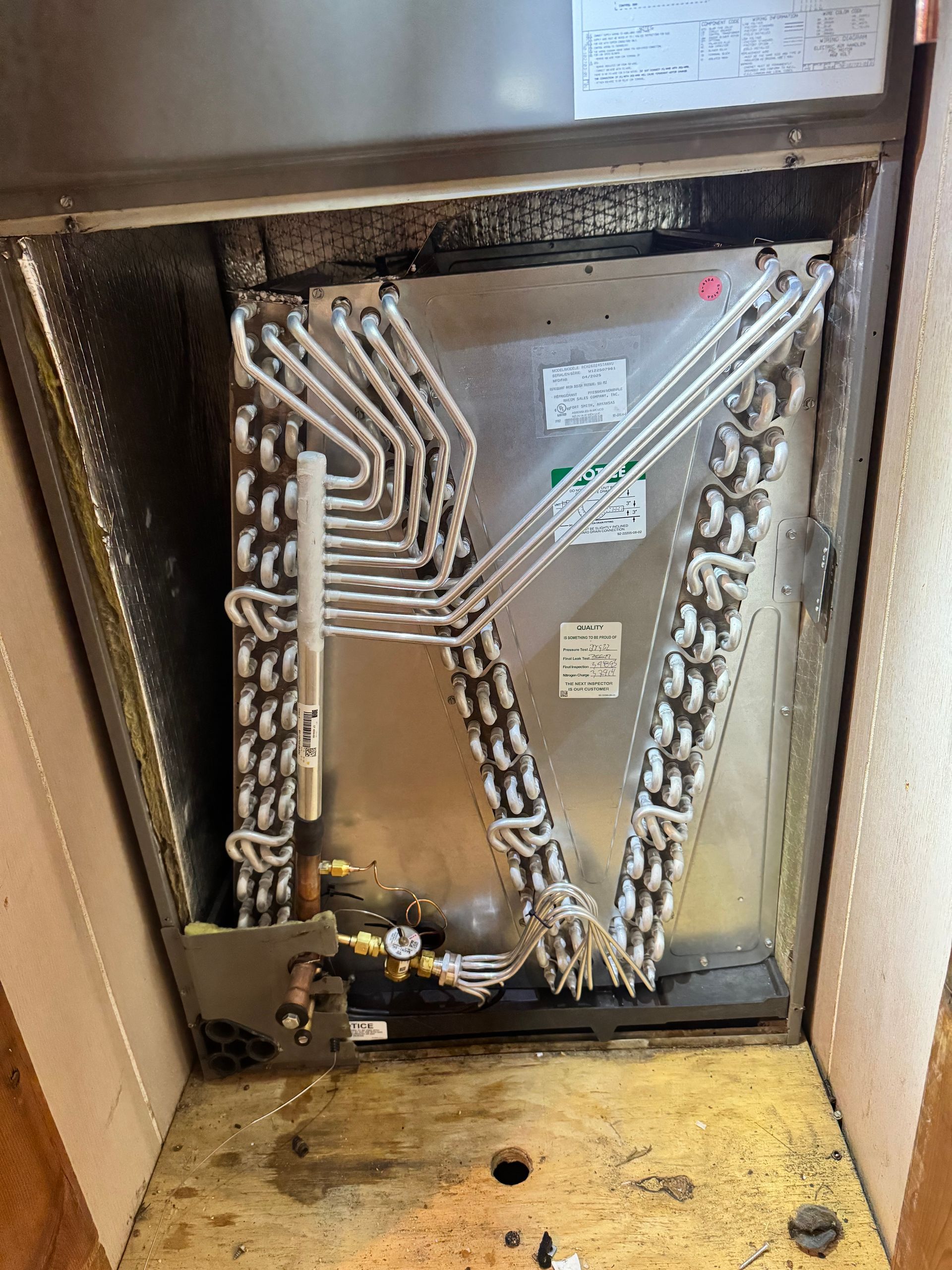 The inside of a refrigerator with a lot of pipes coming out of it.