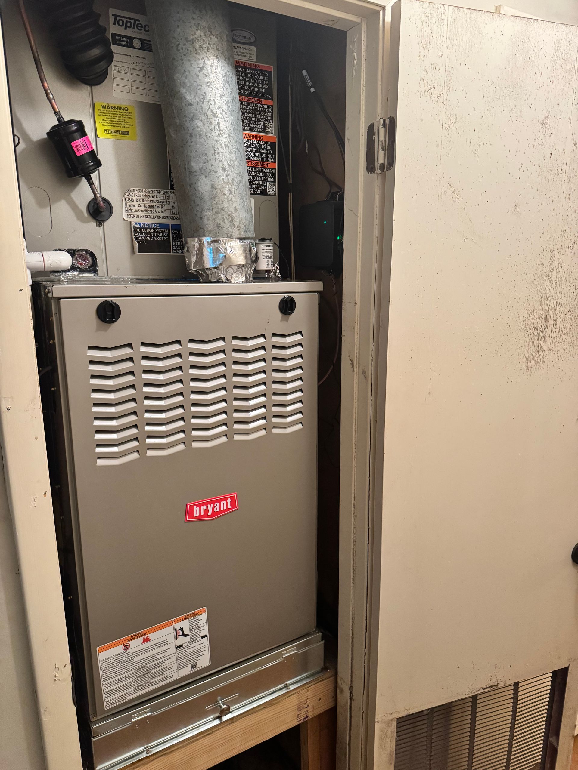 An air conditioner is sitting inside of a closet.