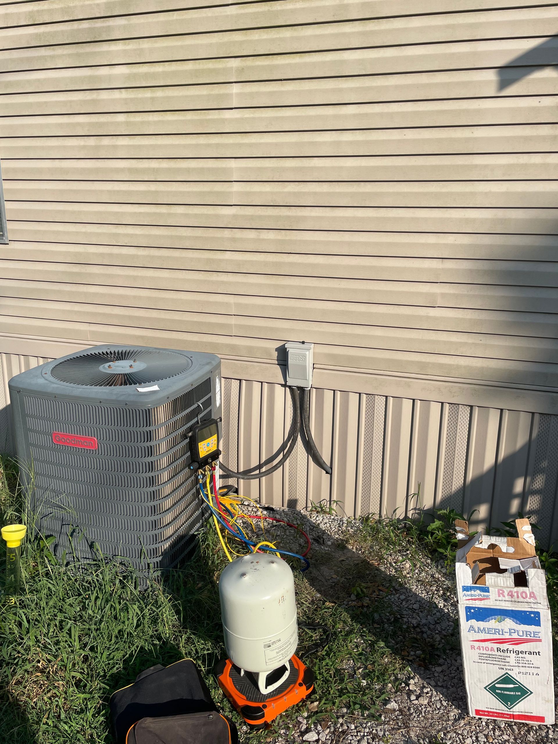 An air conditioner is being installed on the side of a house.