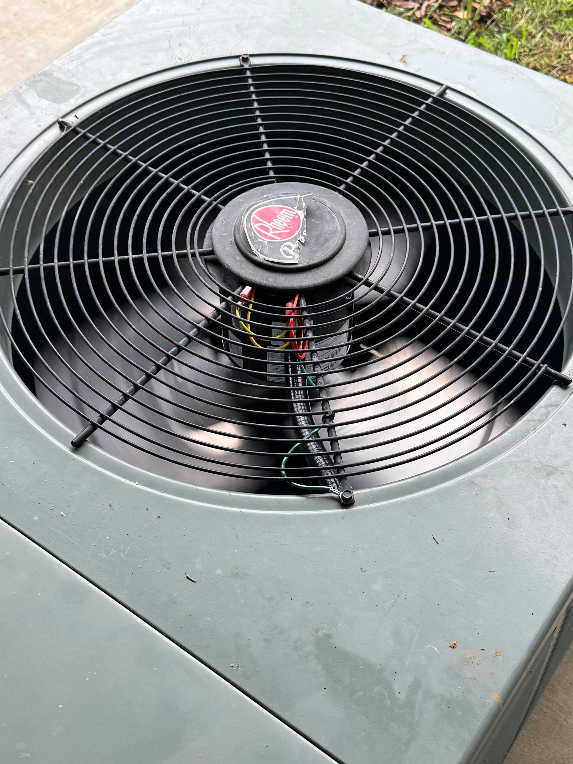 A close up of an air conditioner fan on a concrete surface.
