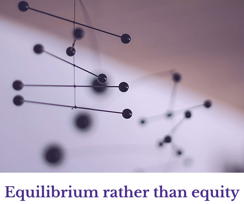 Black mobile art piece hanging, balancing spheres and lines, with soft-focus background. Text: 