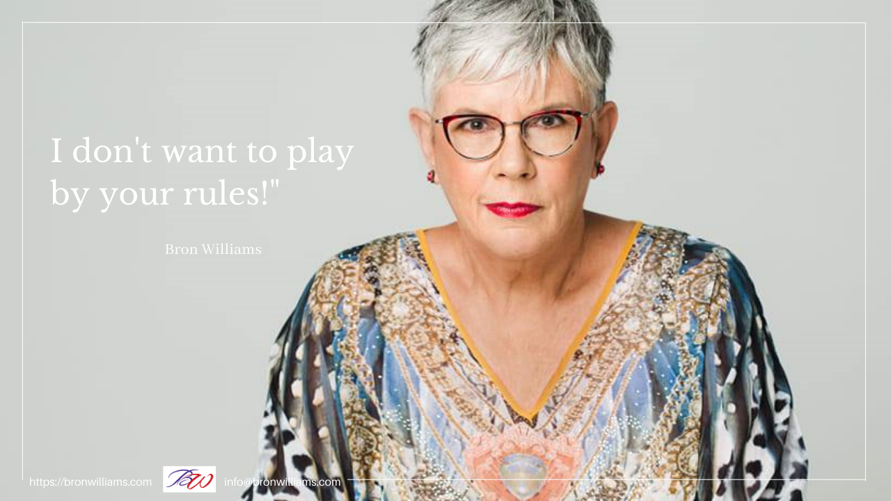 Woman wearing glasses, a colorful patterned top, and red lipstick, looking directly at the viewer; text: 