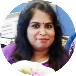 Woman with dark hair, wearing purple, smiling. Pearls around neck.