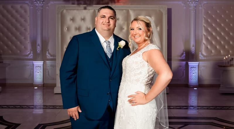 A bride and groom are posing for a picture on their wedding day.