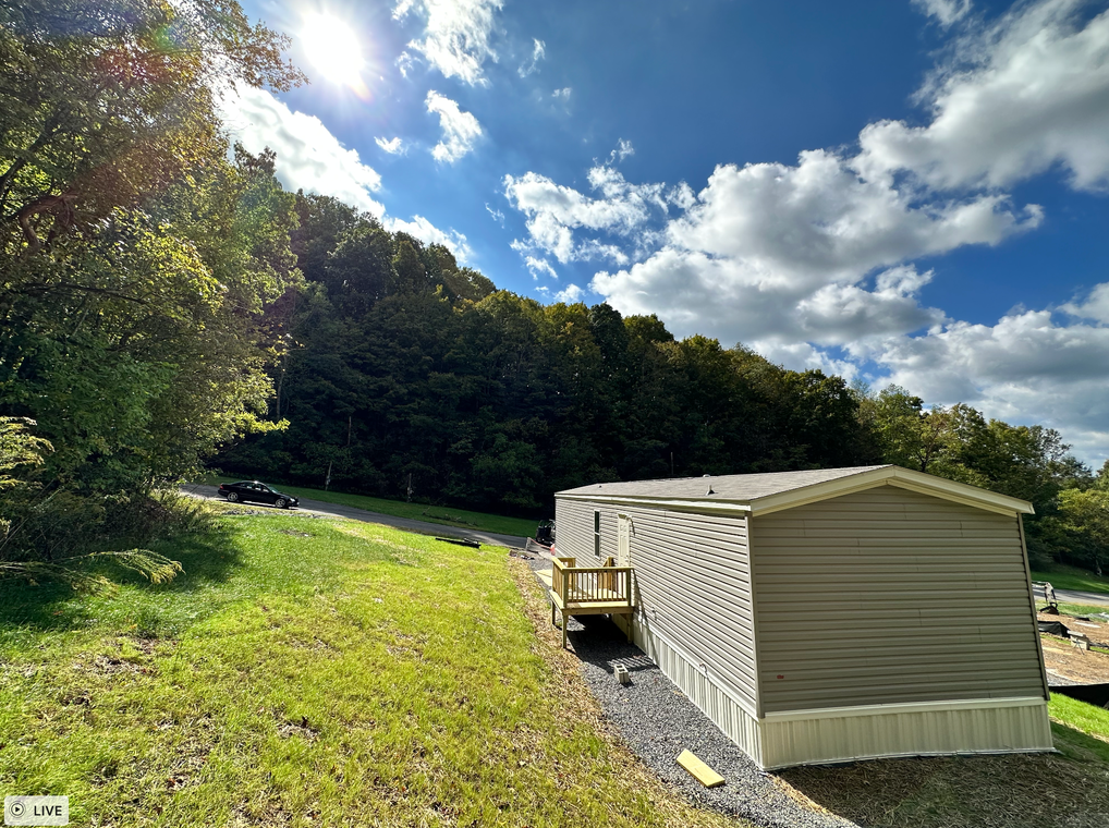 A mobile home is sitting in the middle of a grassy field