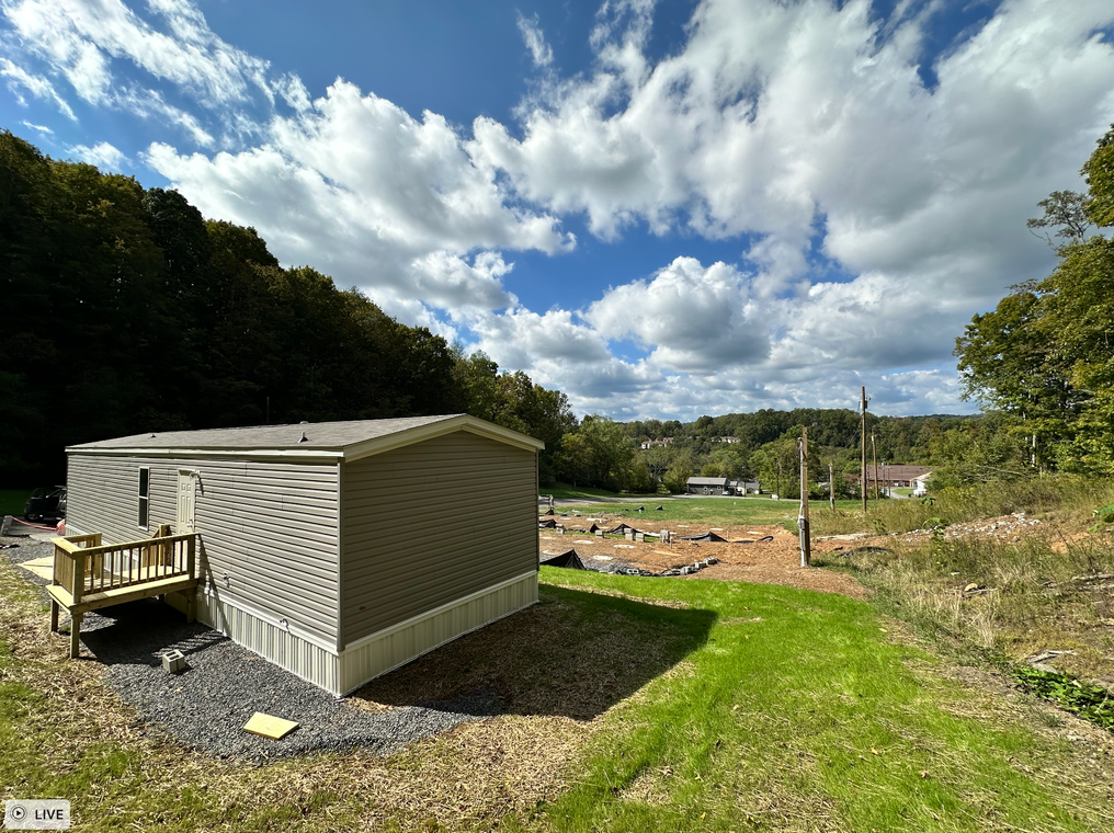 A mobile home is sitting in the middle of a grassy field.