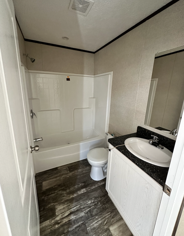 A bathroom with a toilet , sink , and bathtub.