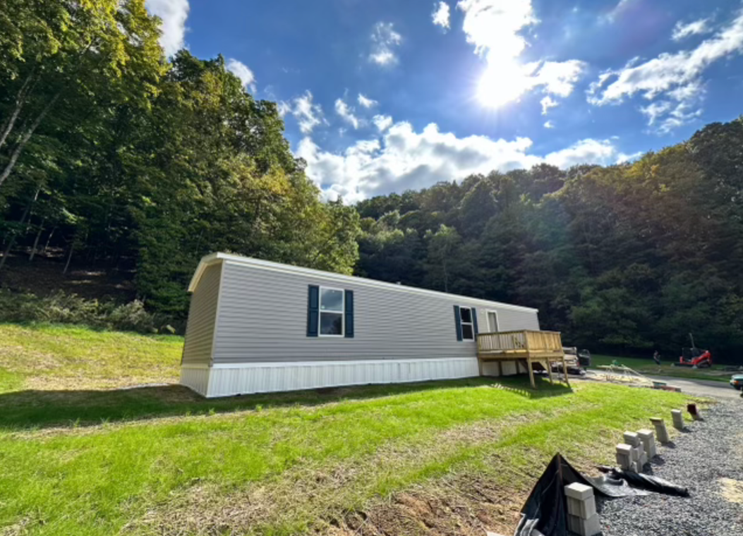 A mobile home is parked in the middle of a grassy field.