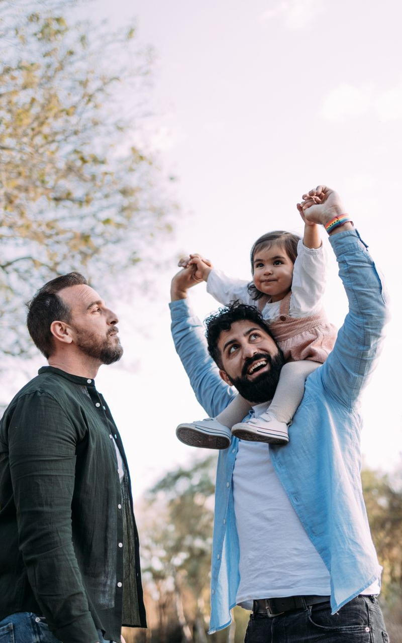 two dads with their child