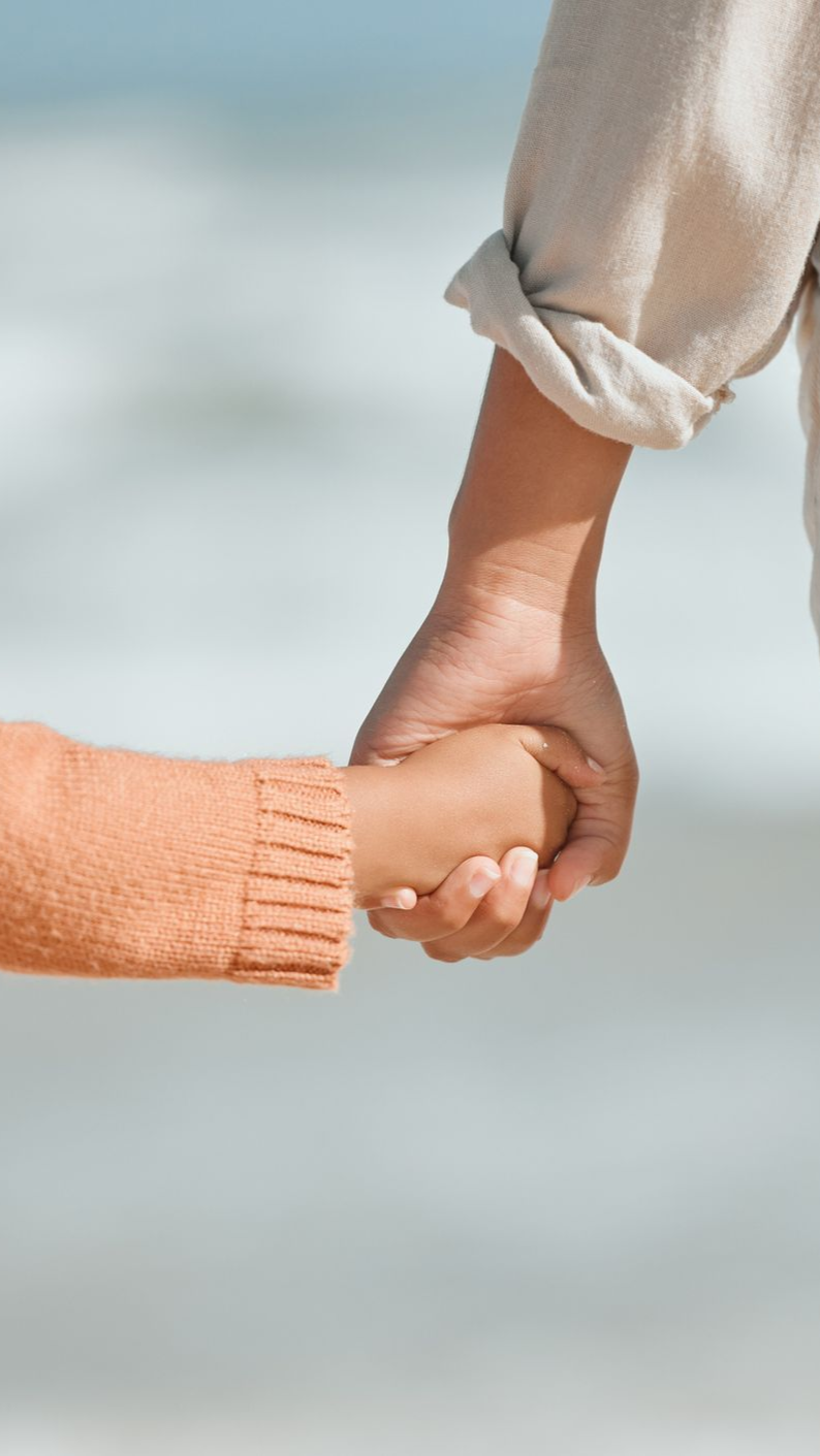 a woman and child holding hands