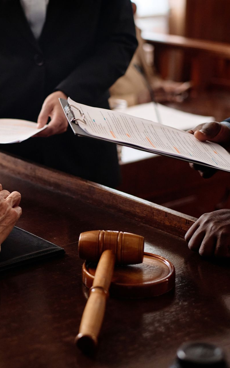 a judge and attorneys with a gavel and documents in a courtroom