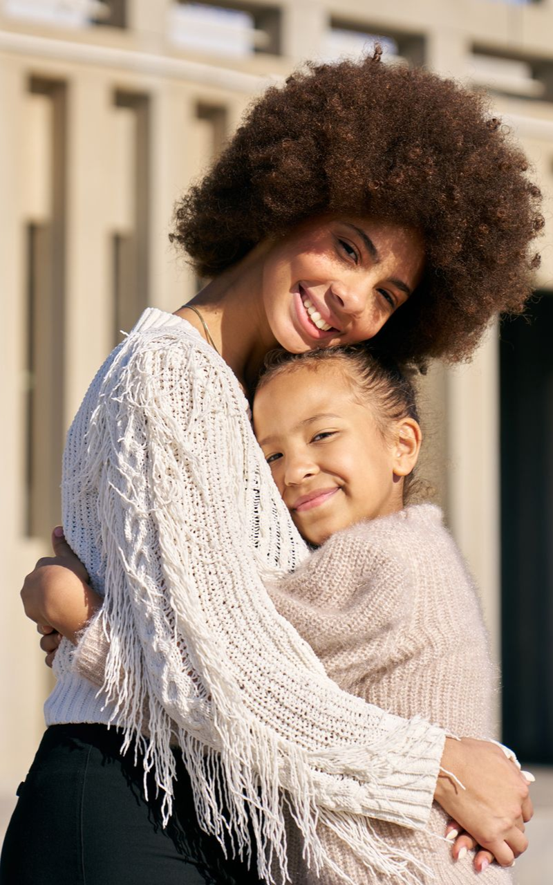a woman hugging her child and smiling