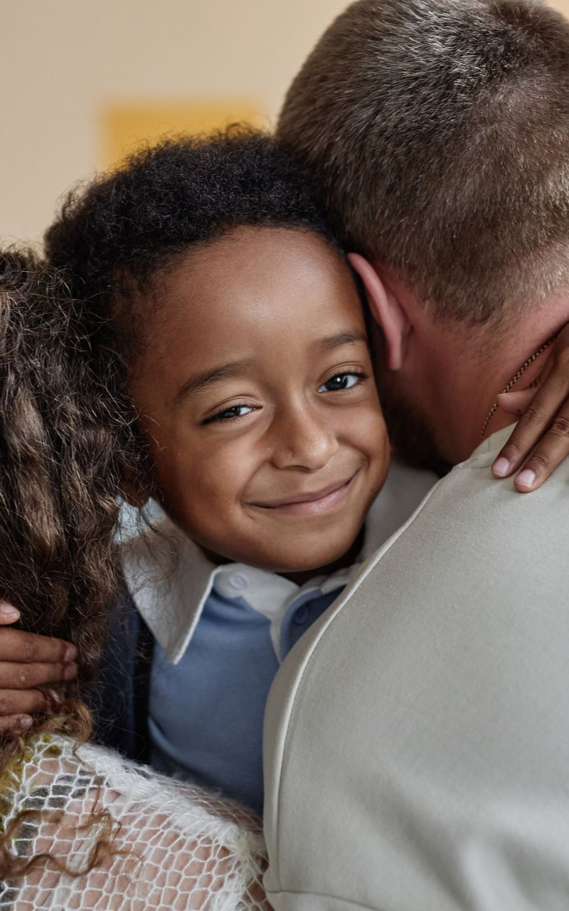 a young boy hugging his parents