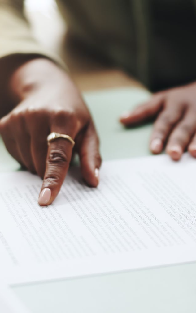 a woman's hand pointing at a document