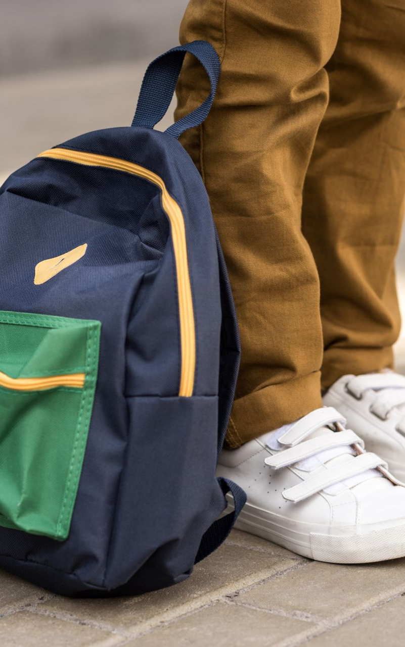 a child with a backpack at their feet