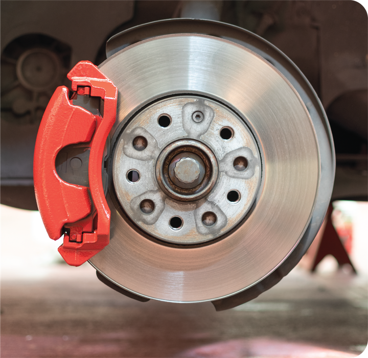 A close up of a car brake with a red caliper