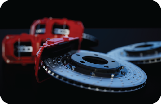 A close up of a brake disc with a red brake caliper in the background