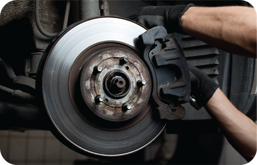 A person is fixing a brake pad on a car.