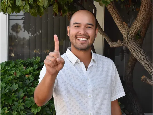 A man in a white shirt is giving a thumbs up sign