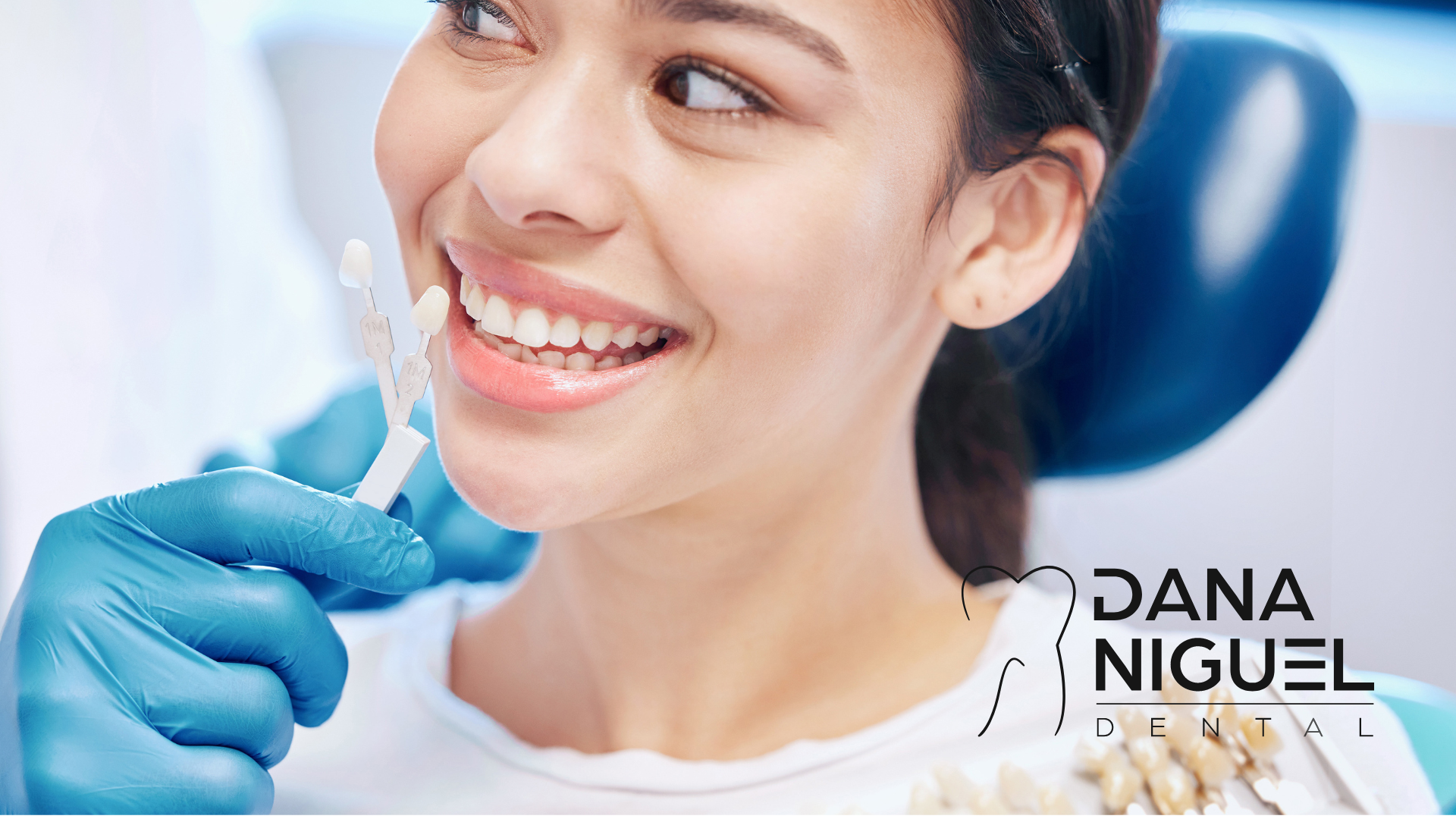 A woman is smiling while getting her teeth examined by a dentist.