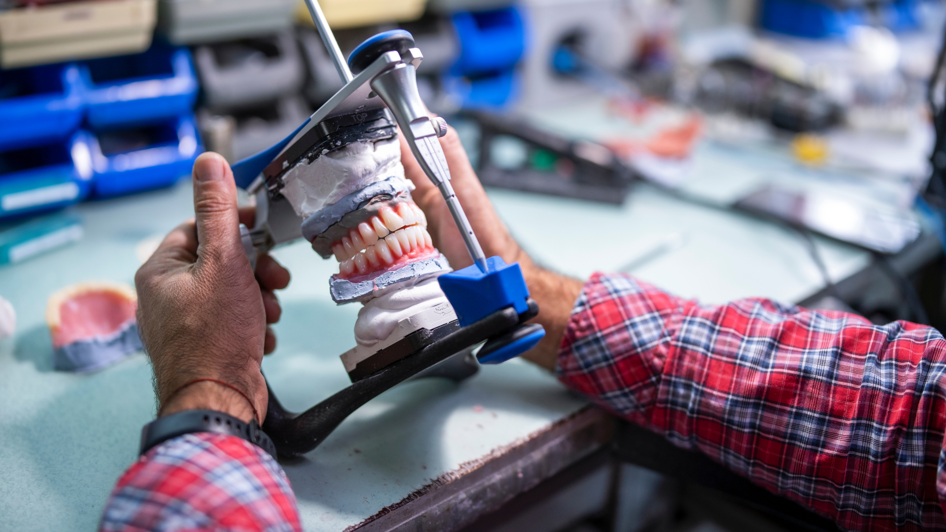 A dentist is working on a model of a person 's teeth.