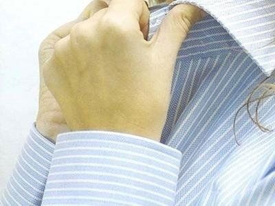 un uomo mentre abbottona la camicia