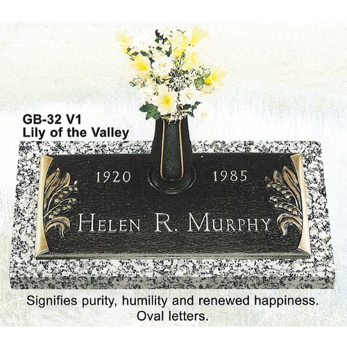 Bronze memorial plaque with flowers. Reads 