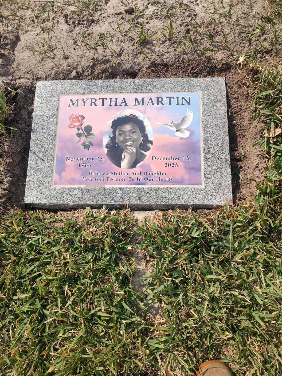 Grave marker for Myrtha Martin; photo of her smiling face, flowers, and a dove.
