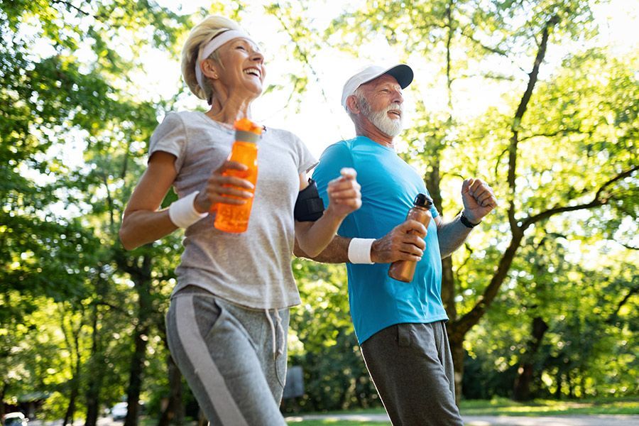 A man and a woman are jogging in a park.