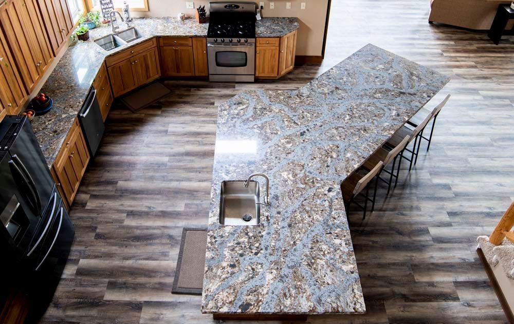 An aerial view of a kitchen with granite counter tops and wooden cabinets.
